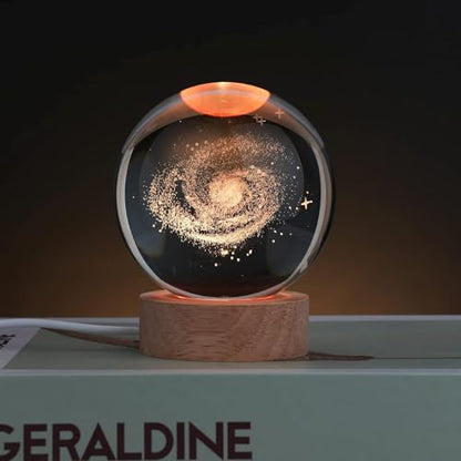 A beautifully crafted glass ball adorned with a colorful space theme, highlighting planets and twinkling stars.