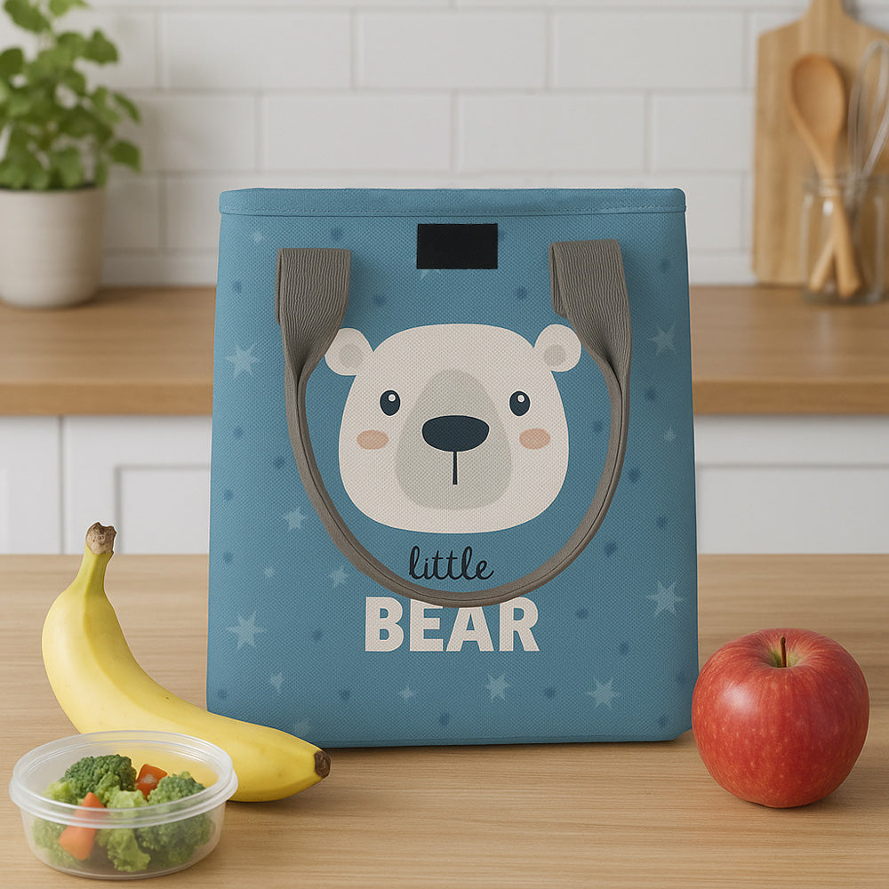 Blue color lunchbag with bear design on a kitchen counter with fruits and vegetables.