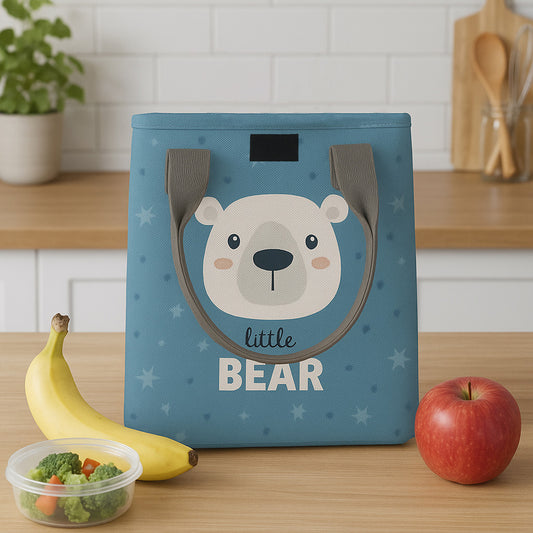 Blue color lunchbag with bear design on a kitchen counter with fruits and vegetables.