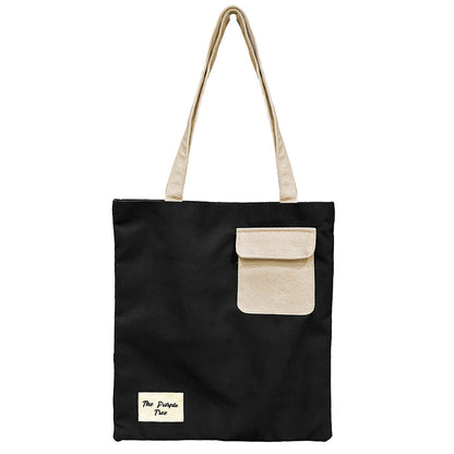 A chic black and white tote bag showcasing a contrasting white pocket, perfect for everyday use and fashion-forward style.