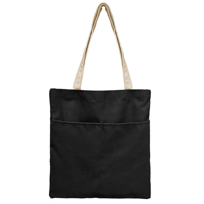 A chic black and white tote bag showcasing a contrasting white pocket, perfect for everyday use and fashion-forward style.