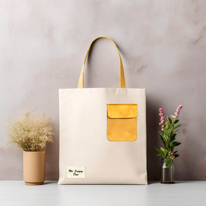 A canvas tote bag with a bright yellow pocket.