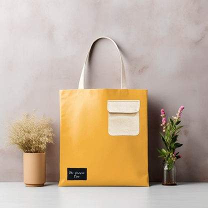 A stylish yellow tote bag with a white pocket, perfect for carrying your essentials.