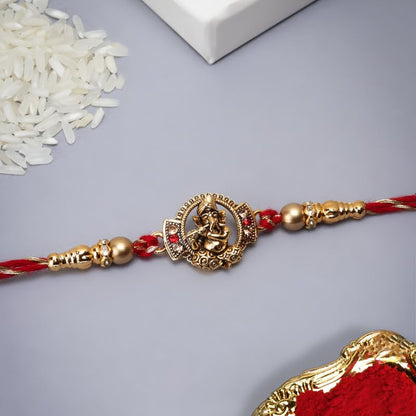 Red and gold rakhi, a traditional Indian bracelet exchanged during Raksha Bandhan festival.