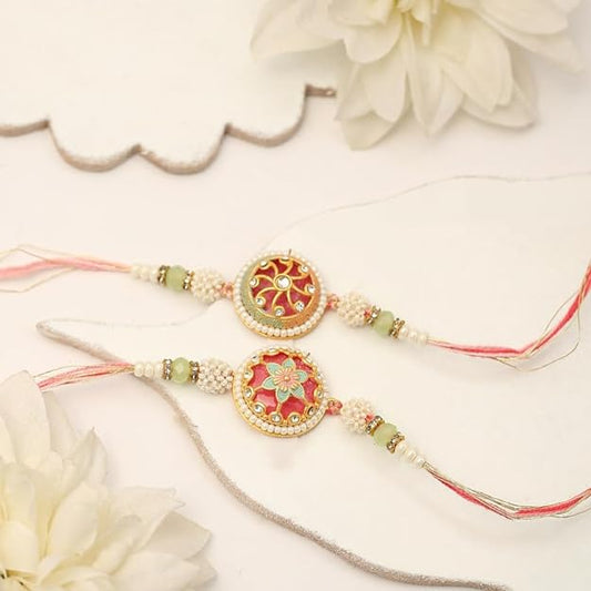 Two rakhi with pink and green beads, symbolizing love and protection during the festival of Raksha Bandhan