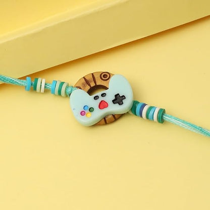 Button-shaped charm with blue and white colors on a Rakhi.