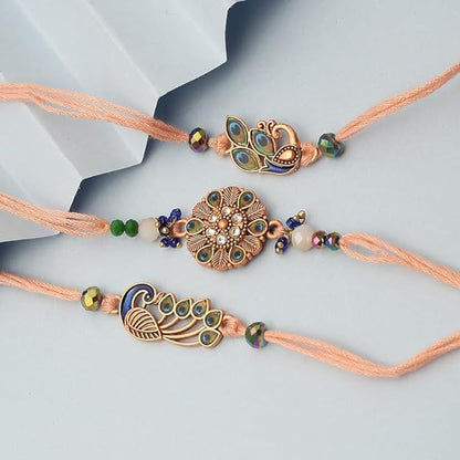 Three vibrant rakhi's in different colors, adorned with a flower and a majestic peacock.