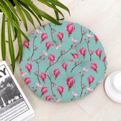 A round floor mat featuring a pattern of pink flowers on a light background.