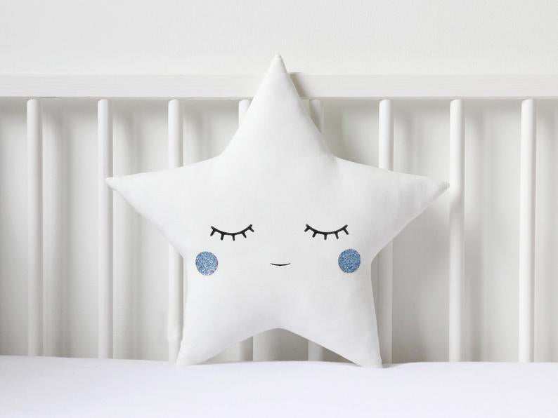 Two white pillows with blue eyes and a star on top, perfect for adding a touch of whimsy to your bedroom decor.