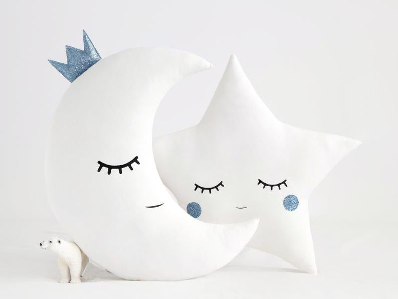 Two white pillows with blue eyes and a star on top, adding a touch of whimsy and charm to any space.