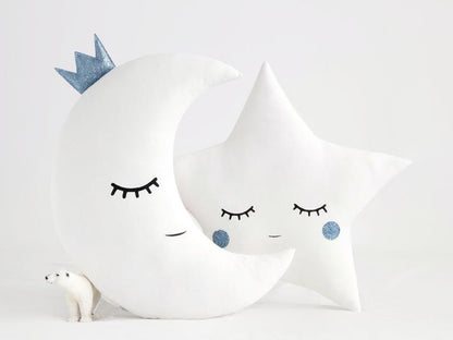 Two white pillows with blue eyes and a star on top, adding a touch of whimsy and charm to any space.
