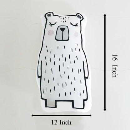 A hand holding a bear pillow against a white background.