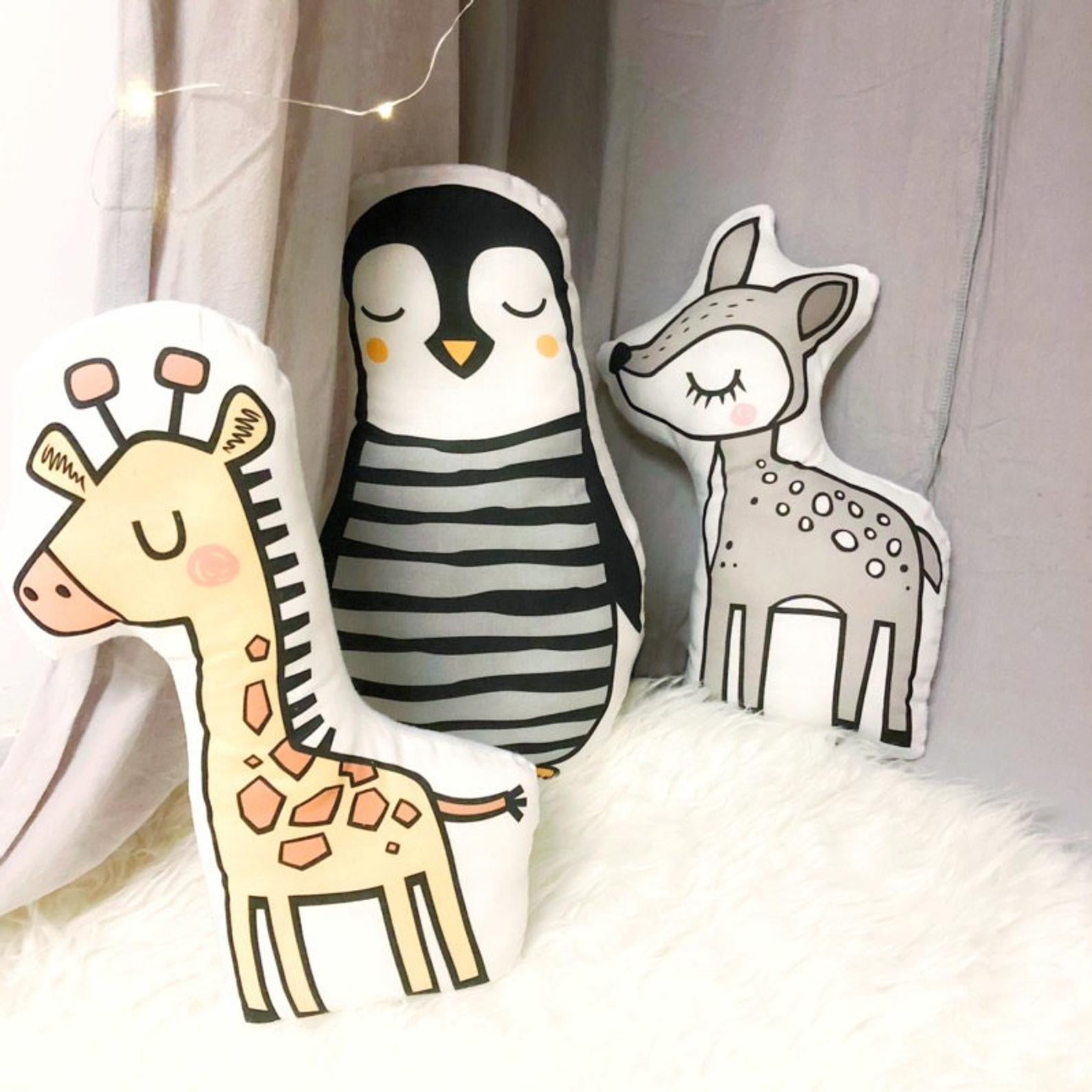Adorable giraffe-shaped pillow placed on a fluffy white rug, creating a playful vibe.