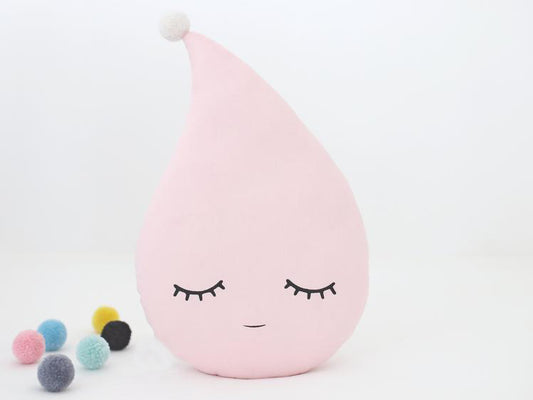  A white pillow with eyes and a yellow dot, perfect for adding a touch of whimsy to your home decor.
