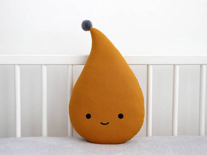 A smiling face pillow placed on a bed, adding a touch of cheerfulness and comfort to the room.