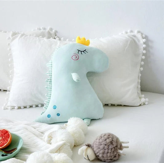 A plush toy wearing a crown rests on a bed, exuding a regal charm.