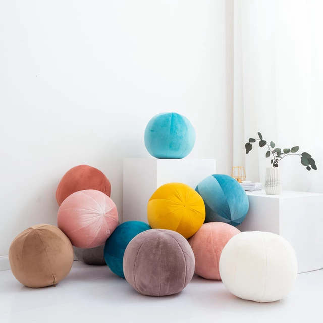 Multicolored balls spread out on white floor.