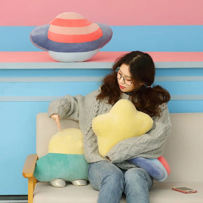 Striped pillow shaped like Saturn in pink and blue.