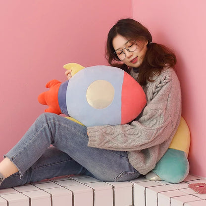 Saturn-shaped pillow with pink and blue stripes.