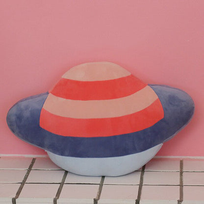 A pink and blue striped Saturn-shaped pillow.