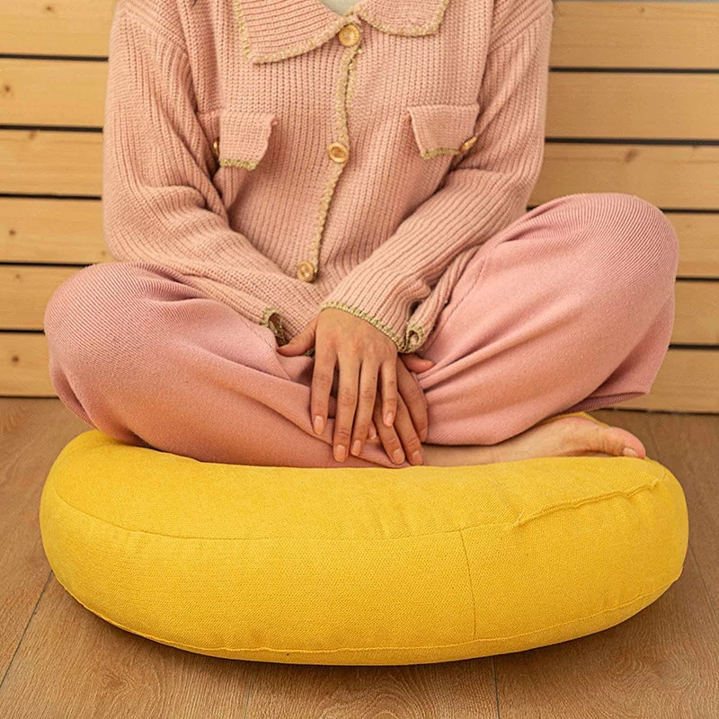Lady relaxing on round yellow pillow.