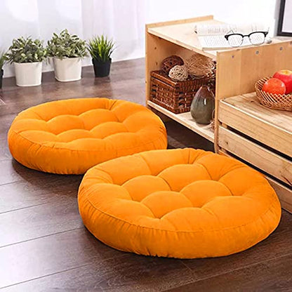  Two Yellow round floor pillows on wooden floor.