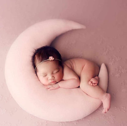 A peaceful newborn girl sleeping on a pink pillow