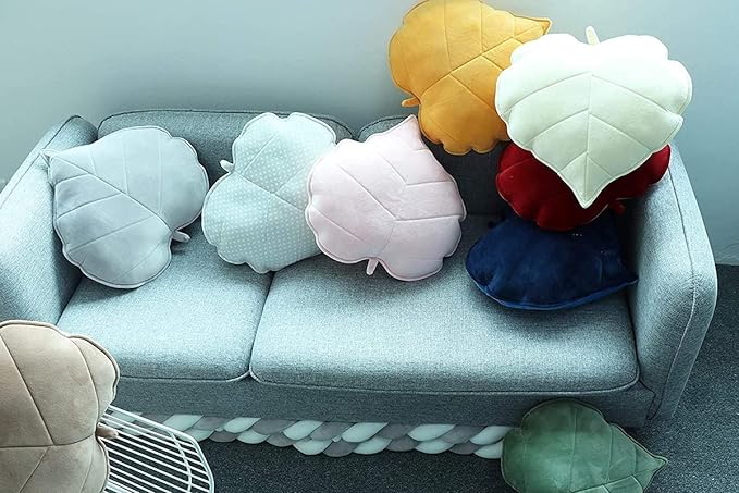 Leafy accent on a couch surrounded by pillows.