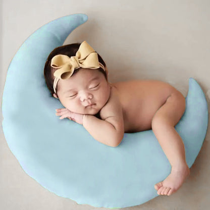 A peaceful newborn girl sleeping on a blue moon, surrounded by tranquility and innocence.