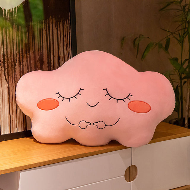 1. A pink cloud-shaped pillow on a table