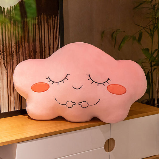 1. A pink cloud-shaped pillow on a table