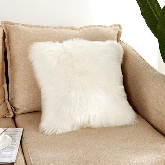 A cozy couch with a white pillow and a lovely plant. Perfect for relaxing and adding a touch of nature to your living space.