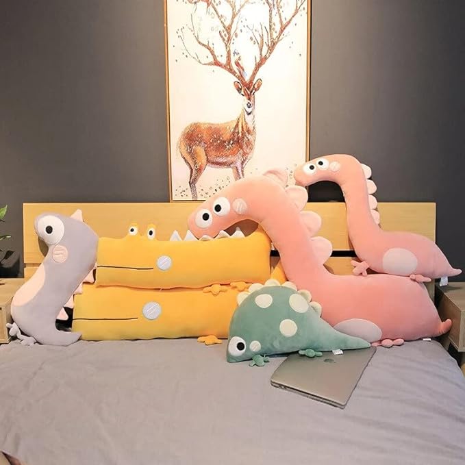 Adorable pink dino toy perched on a bedCute plush toy with tiny head and lengthy tail