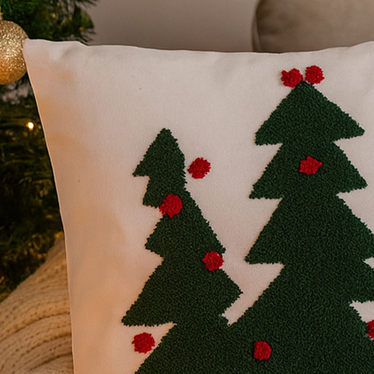 Decorative pillow with green trees and red berries on a neutral background
