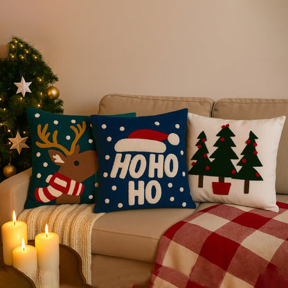 Decorative Christmas pillows on a couch with a Christmas tree in the background