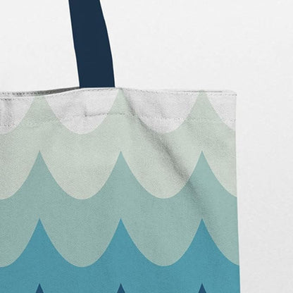 A tote bag with a wave pattern in shades of blue and white, with navy blue handles zoom view