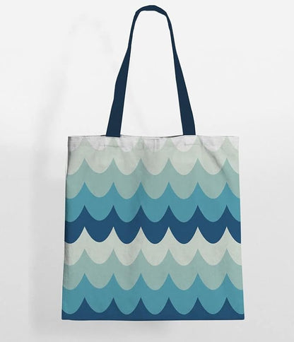 Blue and white tote bag featuring a wave design, perfect for carrying essentials to the beach or pool.