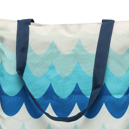 Chic tote bag in blue and white colors, adorned with a wave motif, great for a summer outing or shopping trip.