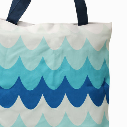 Chic tote bag in blue and white colors, adorned with a wave motif, great for a summer outing or shopping trip.