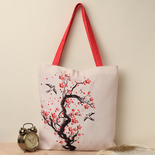 A stylish tote bag with red color handle featuring a beautiful cherry blossom design, perfect for carrying your essentials.