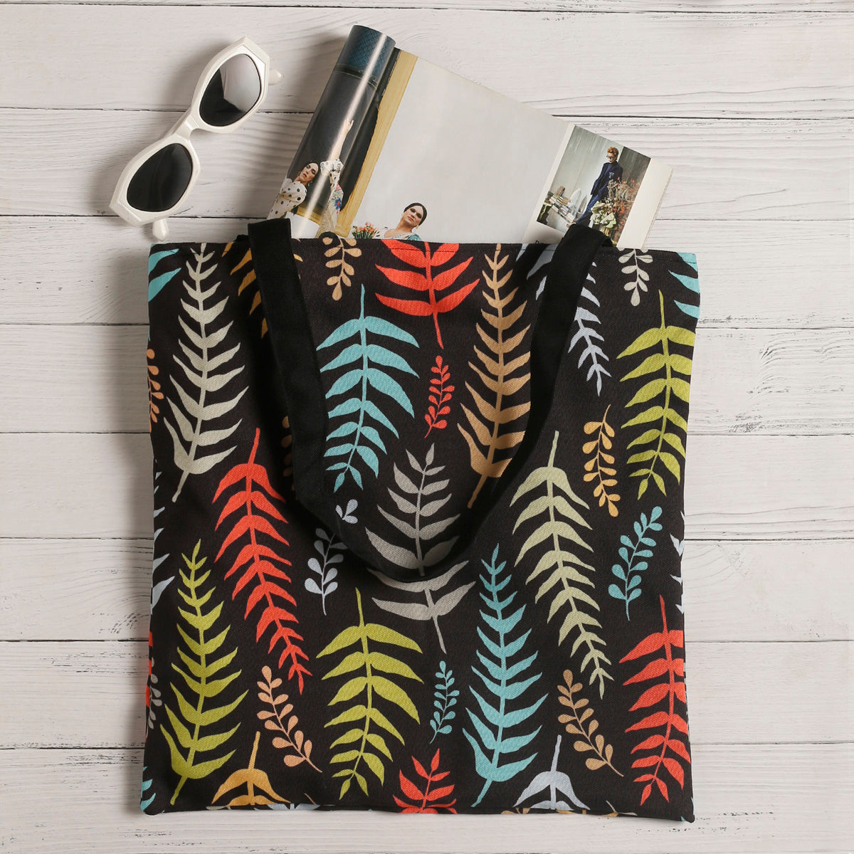 A vibrant tote bag with sunglasses and a fern leaf design, perfect for adding a pop of color to your outfit.