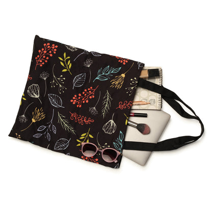 A black tote bag adorned with vibrant leaves and flowers, adding a pop of color to its elegant design.