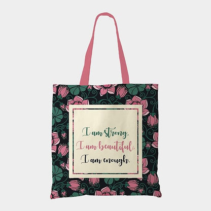 Black tote bag with a quote: ""I am strong, I am beautiful, I am strong"" surrounded by green and pick florals with pink color matching handleTote bag featuring the empowering quote "I am strong, I am beautiful, I am strong".