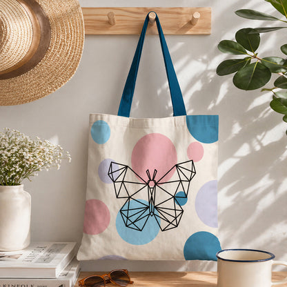 Tote bag with butterfly design hanging on a hook with a plant and books in the background