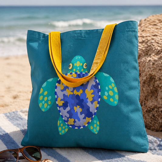 Blue tote bag with a turtle design on a beach
