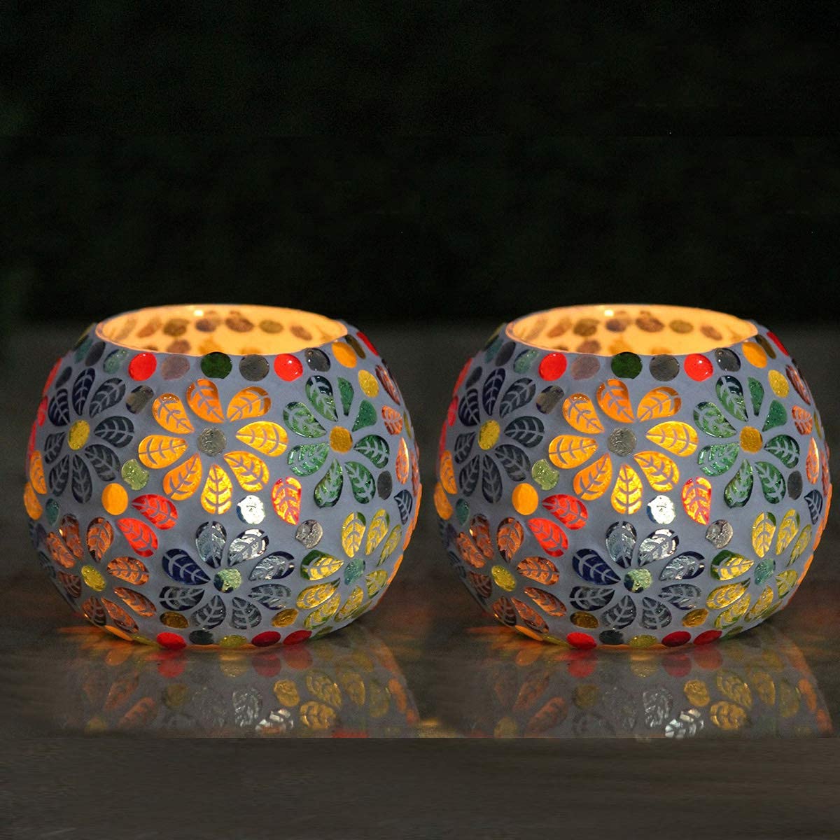 Colorful glass tealights on table.