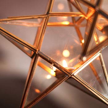  Gold star-shaped light fixture with candle inside, adding warmth and elegance to any room decor.