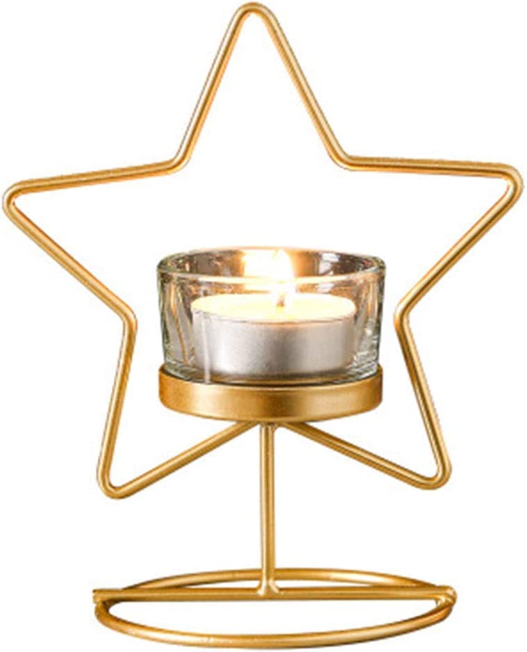  Two decorative star-shaped candles in gold on a table.