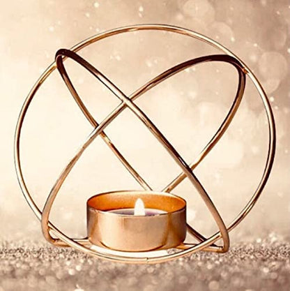 Stylish gold metal tealight holder with purple candle glowing.