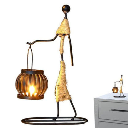 A metal statue with a candle and a flower, symbolizing remembrance and tribute.